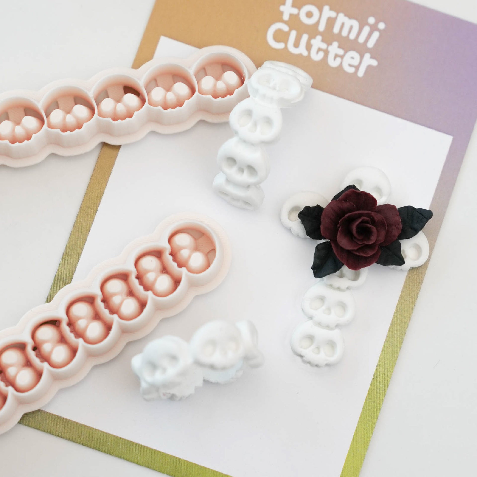 Two continuous skull border polymer clay cutters with finished Halloween clay pieces