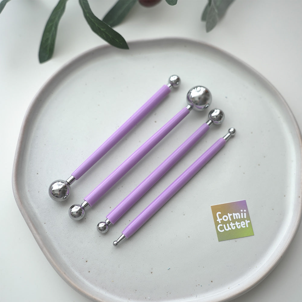 Four purple-handled double-ended ball stylus tools